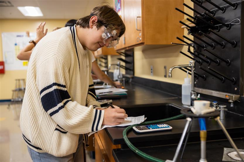 A girl with brown hair does a science experiment